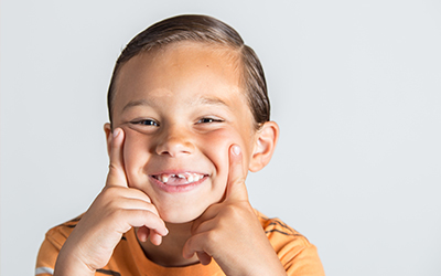 Boy showing missing teeth